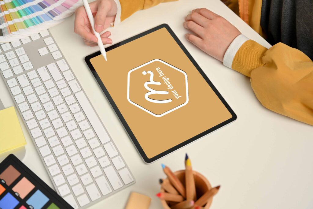 Side view of female designer hand working with digital tablet on computer desk with designer supplies, clipping path